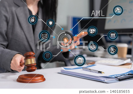 Judge in a courtroom using laptop and tablet with AML anti money laundering icon on virtual screen. 140185655