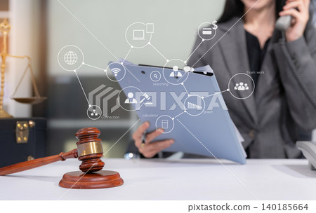 Judge in a courtroom using laptop and tablet with AML anti money laundering icon on virtual screen. Judge in a courtroom using laptop and tablet with AML anti money laundering icon on virtual screen. 140185664
