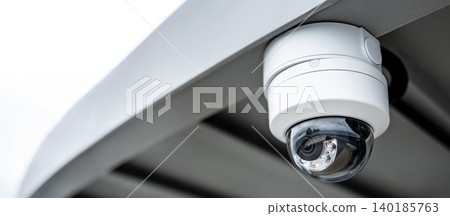 White dome CCTV security camera hanging on steel roof 140185763