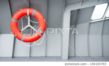 Orange lifebuoy or life preserver ring hanging on side wall of steel boat Orange lifebuoy or life preserver ring hanging on side wall of steel boat 140185765