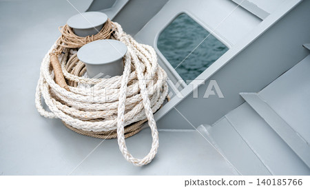 Boat rope or dock lines tied on mooring bollard on metal ship deck Boat rope or dock lines tied on mooring bollard on metal ship deck 140185766