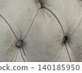 Close-up of textured gray leather upholstery with button detail, suitable for a background 140185950