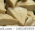 Slices of hard cheese stacked with close-up texture detail, suitable for culinary backgrounds 140185959