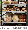 Assorted types of fresh bread displayed on shelves at a bakery, showcasing different varieties 140185961