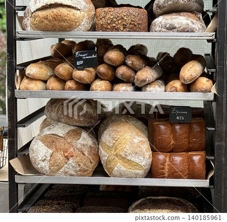 Assorted types of fresh bread displayed on shelves at a bakery, showcasing different varieties Assorted types of fresh bread displayed on shelves at a bakery, showcasing different varieties 140185961