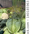 Fresh cabbage and cauliflower on a market stand with green vegetables and leafy textures background 140185963