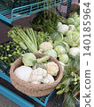 Fresh vegetables including cabbage, cauliflower and cucumbers at farmers market stall display 140185964