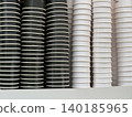 Stacks of black and white disposable coffee cups create minimalist pattern background 140185965
