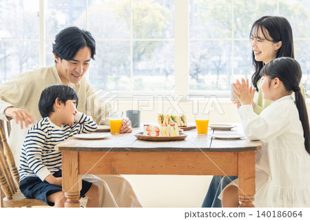 A family eating a meal in the dining room of their home. A family eating a meal in the dining room of their home. 140186064