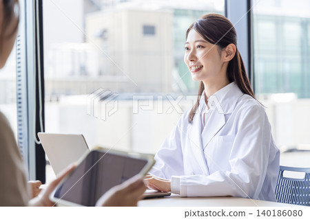 A woman in a white coat provides counseling with a smile. A woman in a white coat provides counseling with a smile. 140186080