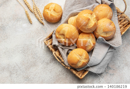 Fresh golden bread rolls in rustic basket Fresh golden bread rolls in rustic basket 140186219