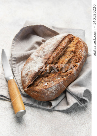 Homemade sourdough rye bread with knife on linen 140186220