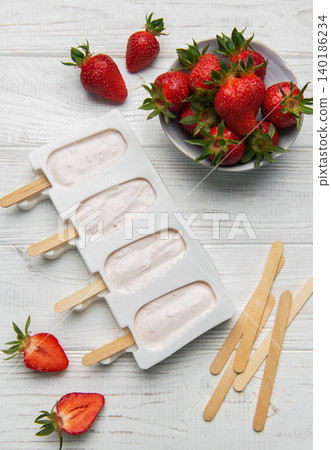 Making strawberry frozen yogurt popsicles for a healthy summer dessert Making strawberry frozen yogurt popsicles for a healthy summer dessert 140186234