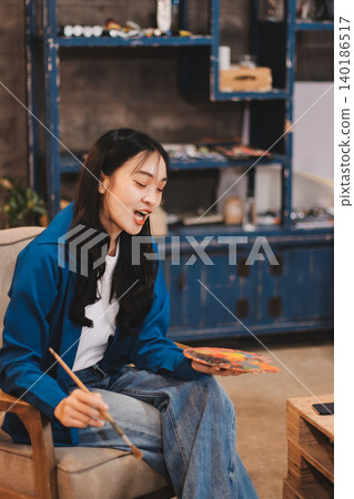 Female artist wears black hat posing near picture indoor the studio Female artist wears black hat posing near picture indoor the studio 140186517