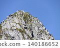 Steep, rocky peaks and mountaintop scenery rising against the blue sky 140186652