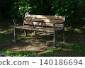 A bench in the park where the sun shines through the trees 140186694