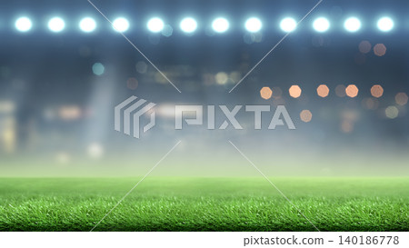 Blurred stadium background with bright floodlights shining on green grass turf at night Blurred stadium background with bright floodlights shining on green grass turf at night 140186778