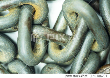 Macro view of interconnected, weathered steel chain links showing rust, wear, and corrosion. Ideal for industrial and security concepts Macro view of interconnected, weathered steel chain links showing rust, wear, and corrosion. Ideal for industrial and security concepts 140186791