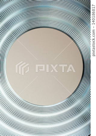 An abstract modern background featuring concentric textured metallic rings in teal and silver, surrounding a central solid beige circle with copy space An abstract modern background featuring concentric textured metallic rings in teal and silver, surrounding a central solid beige circle with copy space 140186817