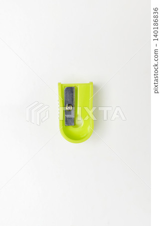 A single bright lime green plastic pencil sharpener shot from above on a clean white background. Perfect for school, office, and creative stationery concepts A single bright lime green plastic pencil sharpener shot from above on a clean white background. Perfect for school, office, and creative stationery concepts 140186836
