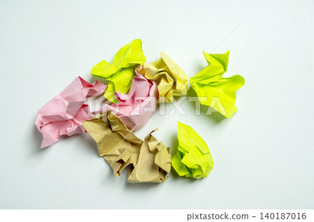 A small pile of colorful crumpled paper balls in pink, yellow, lime green, and brown, isolated on a clean white background. Perfect for concepts of waste, brainstorming, or recycling A small pile of colorful crumpled paper balls in pink, yellow, lime green, and brown, isolated on a clean white background. Perfect for concepts of waste, brainstorming, or recycling 140187016