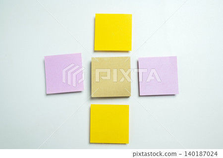 Five blank colorful adhesive notes in a plus sign arrangement on a white surface, ideal for office planning, project management, and creative brainstorming sessions 140187024