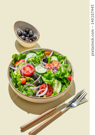 A vegetable salad on a plate on yellow isolated background with shadows. 140187445