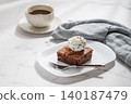 A piece of chocolate brownie with ice cream on a plate and a cup of espresso coffee 140187479