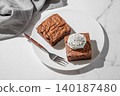 A pieces of chocolate brownie with ice cream on a plate on a light marble background 140187480