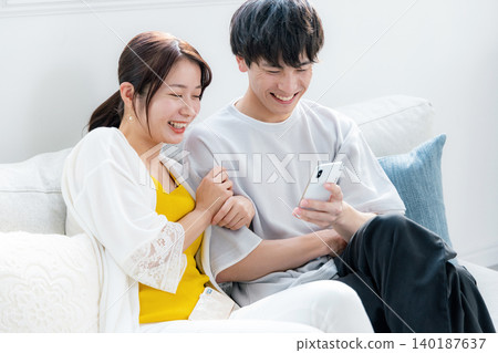 A couple looking at a smartphone A couple looking at a smartphone 140187637