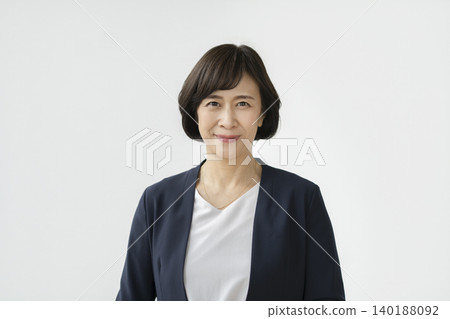 一位六十多歲的女士,穿著西裝,面帶微笑,直視鏡頭。 一位六十多歲的女士,穿著西裝,面帶微笑,直視鏡頭。 140188092