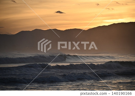 A sunset view of the Shonan coast after a typhoon has passed. Huge waves are crashing against the shore. A sunset view of the Shonan coast after a typhoon has passed. Huge waves are crashing against the shore. 140190166