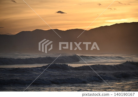 A sunset view of the Shonan coast after a typhoon has passed. Huge waves are crashing against the shore. A sunset view of the Shonan coast after a typhoon has passed. Huge waves are crashing against the shore. 140190167