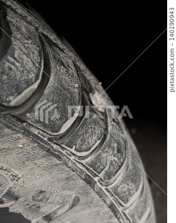 Closeup view of self tapping metal screw in car tire, dirt and grime on surface, need for repair. Deep rubber tread of damaged dusty vehicle wheel. Repair service, accident with punctured tires Closeup view of self tapping metal screw in car tire, dirt and grime on surface, need for repair. Deep rubber tread of damaged dusty vehicle wheel. Repair service, accident with punctured tires 140190943