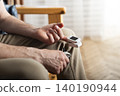 Caucasian middle aged man using pulse oximeter at home 140190944