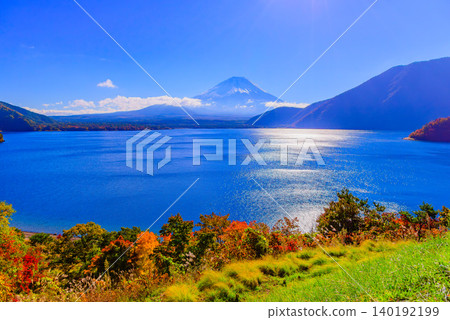 On a clear autumn morning, from Lake Motosu Observation Park, adorned with colorful autumn leaves, you can see the snow-capped Mount Fuji and the sparkling surface of the lake. 140192199