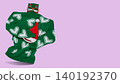 Funny invisible character concept with green knitted sweater holding Santa hat and wearing Christmas party glasses, levitating on purple background. 140192370