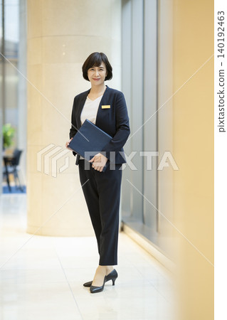 A portrait of a businesswoman in her 60s smiling directly at the camera. A portrait of a businesswoman in her 60s smiling directly at the camera. 140192463