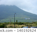 A passenger plane landing with Mount Hachijo-Fuji in the background. 140192624
