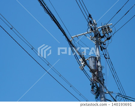 由電線桿和電線構成簡單的天空構圖。 由電線桿和電線構成簡單的天空構圖。 140193691