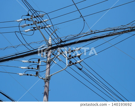 由電線桿和電線構成簡單的天空構圖。 由電線桿和電線構成簡單的天空構圖。 140193692