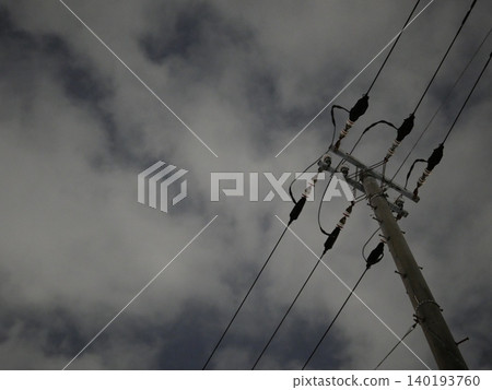 A quiet urban landscape of utility poles and power lines stretching into the night sky. 140193760