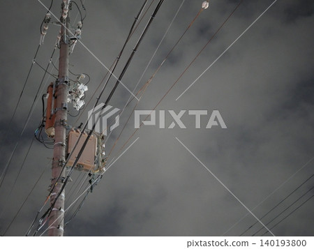 A minimalist night view of power lines and utility poles floating in the dark sky. A minimalist night view of power lines and utility poles floating in the dark sky. 140193800