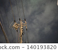 The silent silhouettes of utility poles and power lines stretching into the night sky. 140193820