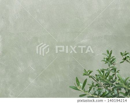 A horizontal background image featuring green olive branches and leaves in front of a pale olive-colored wall. A horizontal background image featuring green olive branches and leaves in front of a pale olive-colored wall. 140194214