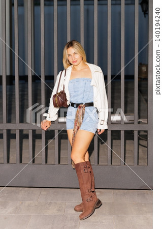 Woman posing in street style denim romper Woman posing in street style denim romper 140194240