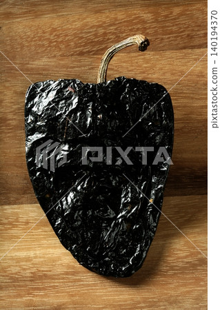 One black mexican dried chili pepper still One black mexican dried chili pepper still 140194370