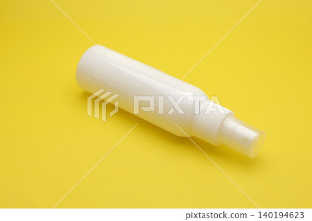 white spray bottles stand neatly against a vibrant yellow backdrop. Minimalist design suggests versatility for skincare or cleaning applications. Clean surfaces imply hygiene and simplicity white spray bottles stand neatly against a vibrant yellow backdrop. Minimalist design suggests versatility for skincare or cleaning applications. Clean surfaces imply hygiene and simplicity 140194623