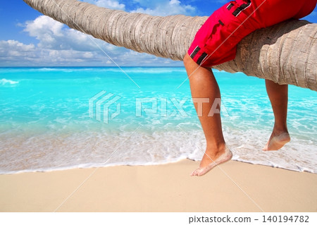 Caribbean inclined palm tree beach tourist legs Caribbean inclined palm tree beach tourist legs 140194782