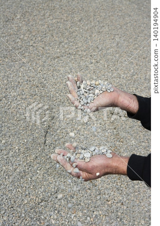 gravel rolling stones falling man hands in quarry background 140194904